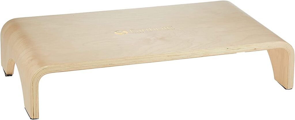 EARTHLITE solid hardwood step stool used as a desk footrest