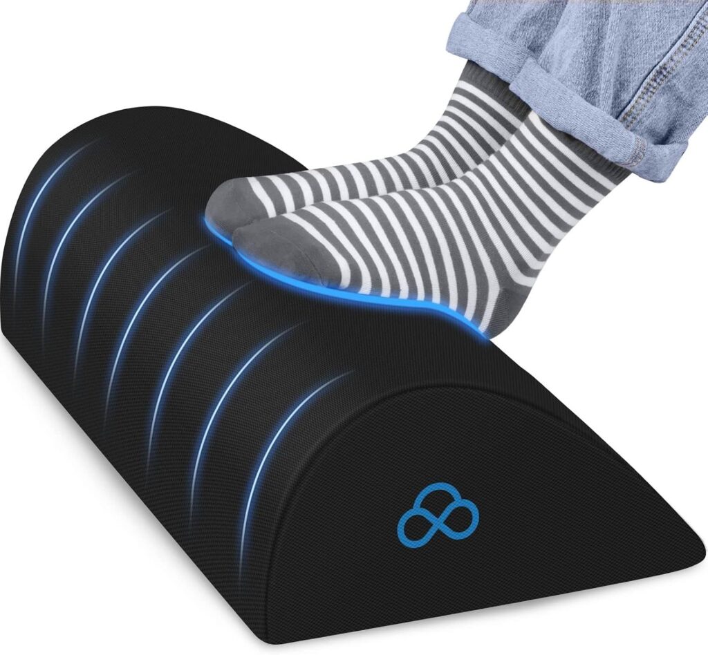 Black foam foot rest pillow shaped for under desk use with a washable cover